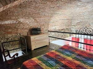 a bedroom with a colorful bed and a brick wall at Comfort Accommodation Loft in Bergamo