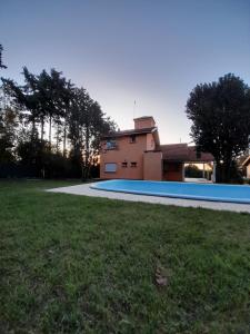 a house with a swimming pool in front of a yard at Casa Naranja in Merlo