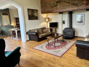 a living room with a couch and a stove at Hoeve de Knol in Holthees