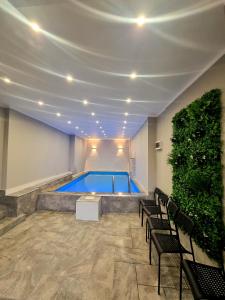 a swimming pool in a room with chairs and a plant at Complex Veverița Rânca in Ranca