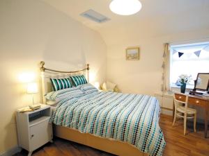 a bedroom with a bed and a desk and a window at Shrimp Cottage - E5415 in Kessingland