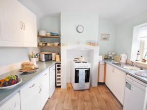 a kitchen with white cabinets and a stove at Shrimp Cottage - E5415 in Kessingland