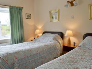 a bedroom with two beds and a window at Manor Cottage in Old Byland