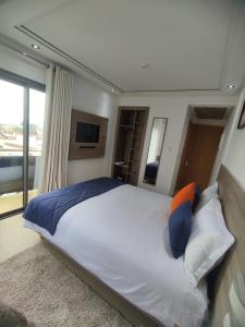 a bedroom with a large bed and a television at LOTUS HOTEL Casanearshore in Casablanca