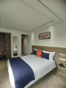 カサブランカにあるLOTUS HOTEL Casanearshoreのベッドルーム1室(大型ベッド1台、青とオレンジの枕付)