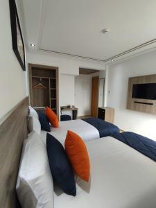 1 dormitorio con 2 camas con almohadas de color naranja y azul en LOTUS HOTEL Casanearshore, en Casablanca