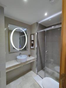 カサブランカにあるLOTUS HOTEL Casanearshoreのバスルーム(シンク、鏡付きシャワー付)