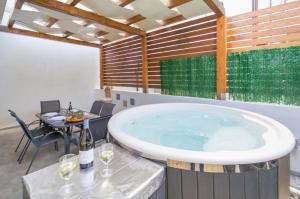 una gran bañera en una habitación con una mesa y copas de vino en Al Mare, en Portopalo di Capo Passero