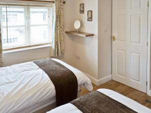 a bedroom with two beds and a window at Baytree Cottage 1 in Birch