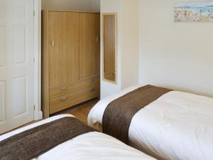 um quarto com 2 camas e um armário em Baytree Cottage 1 em Birch