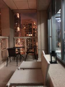 a balcony with a table and chairs and a view of a city at Downtown Boulevard one bedroom Apt in 29 blvd غرفة وصالة Burj & fountain View Master bedroom plus 2 single beds in living room in Dubai