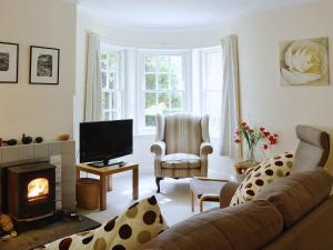 a living room with a couch and a fireplace at Dunlappie Lodge in Edzell