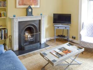 a living room with a fireplace and a tv at 33 Chapel Street in Penzance