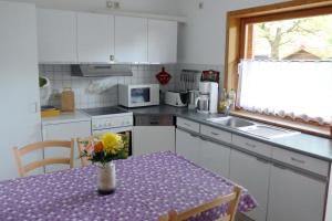 a kitchen with a table with a vase of flowers on it at An-Hog-Barg-1 in Godern