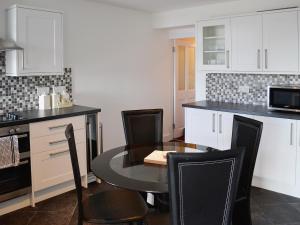 a kitchen with a table and chairs in a kitchen at Sea-esta - 28175 in Port William