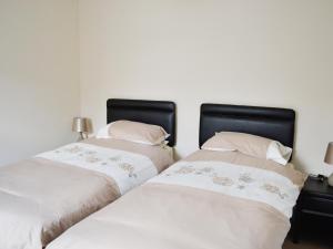 two beds sitting next to each other in a bedroom at Sea-esta - 28175 in Port William