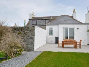 a white house with a wooden bench in the yard at Sea-esta - 28175 in Port William