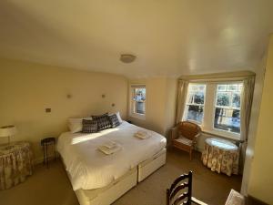 a bedroom with a large white bed and two windows at Midsomer Cottage- Spacious Victorian Cottage with parking & garden - Close to City and ring road in Oxford