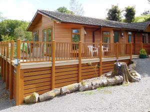 a log cabin with a porch and a deck at Ransome Lodge in High Nibthwaite