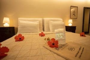 a bedroom with a bed with red flowers on it at Beija Flor Exclusive Hotel & Spa in Pipa