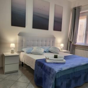 1 dormitorio con 1 cama con sábanas y almohadas azules en Bed and Breakfast Mare Blu, en Civitavecchia