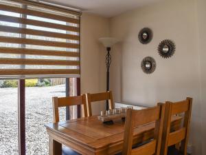 a dining room with a wooden table and two mirrors at Leighwood in Sandwich