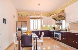 uma cozinha com uma mesa e cadeiras e um frigorífico em Villa Capri em Fiuzzi