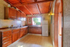 una cucina con mobili in legno e un frigorifero bianco di Villa in Fontane Bianche by Turquoise Waters a Fontane Bianche