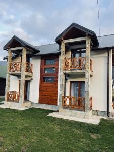 a house with wooden doors and a balcony at Chalet Montenegrina with jacuzzi in Kolašin
