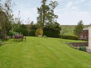 a lawn with a picnic table in a yard at Ellarbeck Cottage in Caldbeck