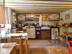 a kitchen with wooden cabinets and a table and chairs at Om Shanti - 28602 in Tipton Saint John