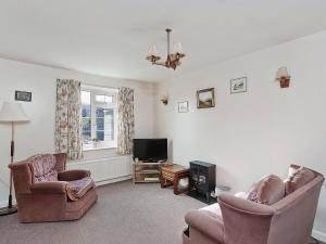 a living room with two chairs and a television at Peartree Farm Cottages - Rchm39 in Ebberston