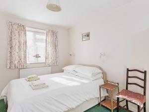a bedroom with a bed and a chair and a window at Peartree Farm Cottages - Rchm39 in Ebberston