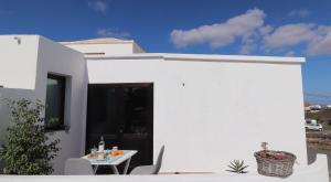 een wit huis met een witte tafel en stoelen bij CASA los senderos in Tinguatón