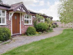 a red brick house with a driveway at Walled Garden Lodge in Ryhill