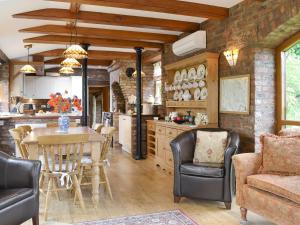 a kitchen and dining room with a table and chairs at Walled Garden Lodge in Ryhill