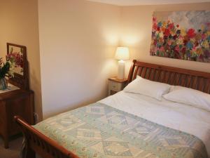 a bedroom with a bed and a painting on the wall at Grain Store 2 - 29636 in Portloe