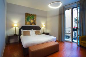 a bedroom with a large bed and a balcony at Isula in Palermo