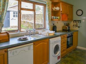 een keuken met een wastafel en een wasmachine bij Paddock Cottage in Alnwick