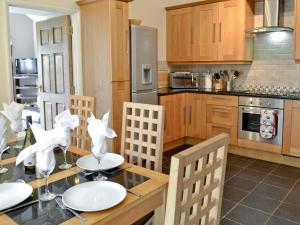 a kitchen with a table with white plates on it at West Rose Barn in Pendine