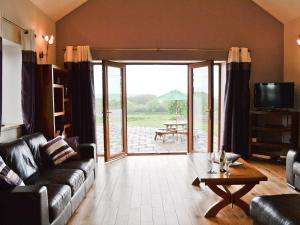 a living room with a couch and a table at West Rose Barn in Pendine