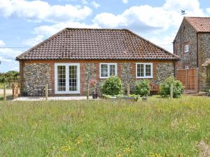 a brick house with a field in front of it at Dog Rose Cottage in Great Dunham
