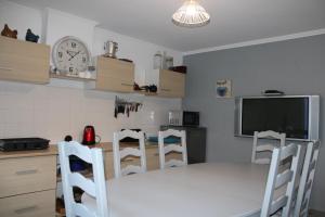 cocina con mesa y sillas y TV en Chambres d'hotes chez laure & François en Paimpol