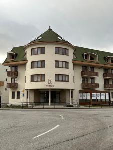 a large white building with a green roof at Apartment MyMara No3 in Bešeňová