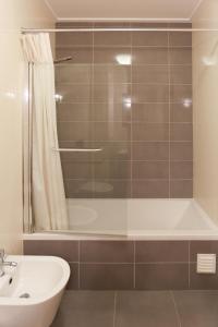 een badkamer met een douche, een bad en een wastafel bij Carmona G in São Martinho do Porto
