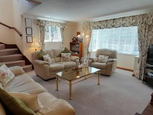 a living room with two couches and a coffee table at Laurel Cottage in Sway