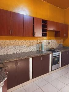 a kitchen with brown cabinets and a stove top oven at Cheerful Villa Nyamata in Kayenzi