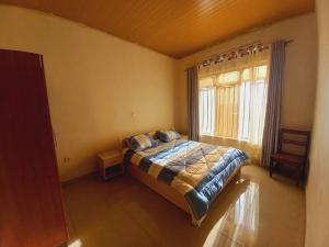 a bedroom with a bed and a large window at Cheerful Villa Nyamata in Kayenzi