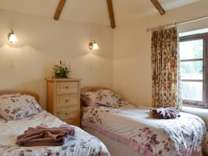 2 camas individuales en una habitación con ventana en Stable Cottage, en East Meon