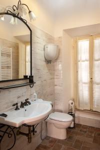 een badkamer met een wastafel, een toilet en een spiegel bij il Rifugio dell'Artista in Passignano sul Trasimeno